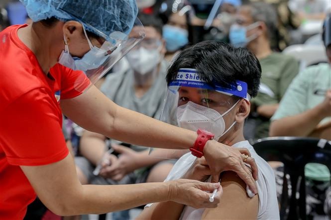 Nhân viên y tế tiêm vaccine phòng COVID-19 cho học sinh tại San Juan, Philippines, ngày 3/11/2021. Ảnh: THX/ TTXVN