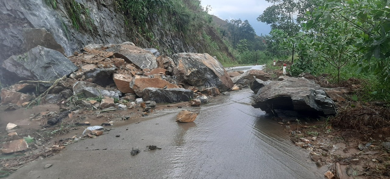 Nhiều cục đá to tràn xuống đường quốc phòng từ Trà Dơn vào Trà Leng (Nam Trà My) gây khó khăn cho công tác khắc phục hậu quả sạt lở. Ảnh: TM.