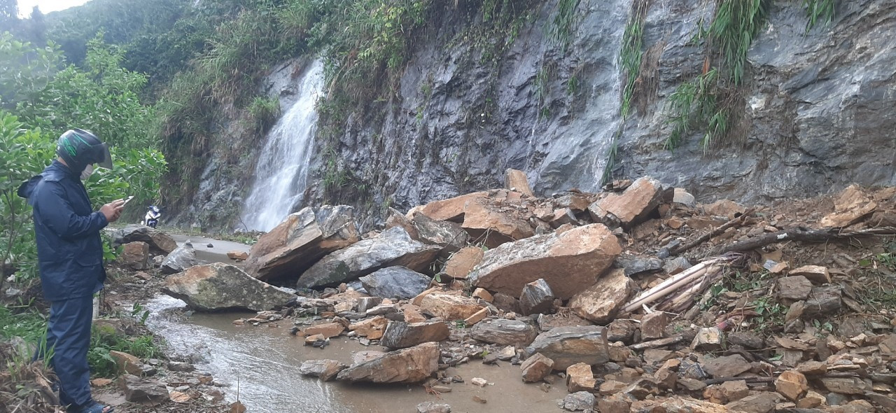 Nhiều cục đá to tràn xuống đường quốc phòng từ Trà Dơn vào Trà Leng (Nam Trà My) gây khó khăn cho công tác khắc phục hậu quả sạt lở. Ảnh: TM.