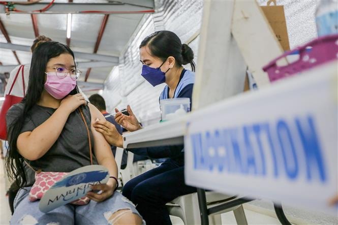 Nhân viên y tế tiêm vaccine phòng Covid-19 cho học sinh tại Marikina, Philippines, ngày 29-11-2021. Ảnh: THX/ TTXVN