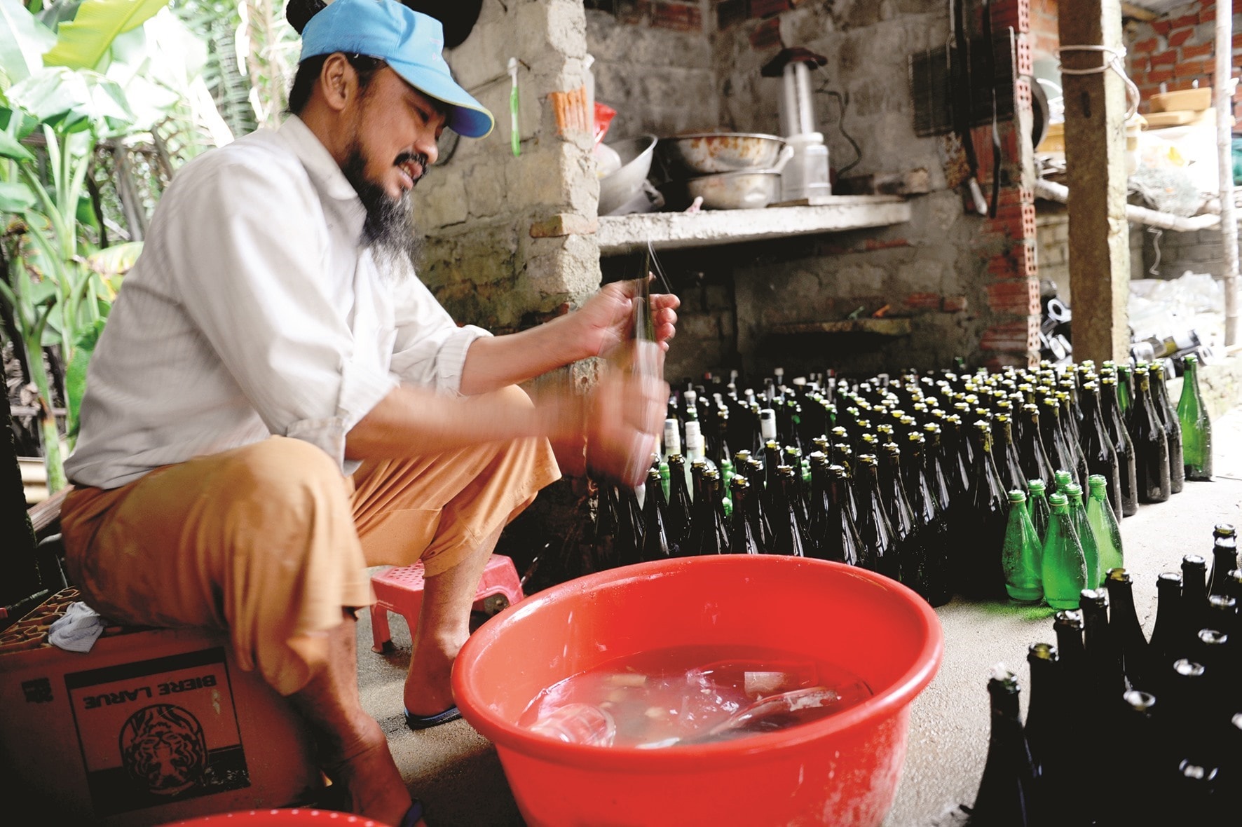 Mr. Linh cleans the bottles he collects It may take him 20 years to complete the house with 20,000 bottles.