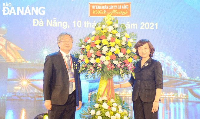 Phó Chủ tịch UBND thành phố Ngô Thị Kim Yến (phải) tặng hoa chúc mừng hội nghị. Ảnh: THU HÀ