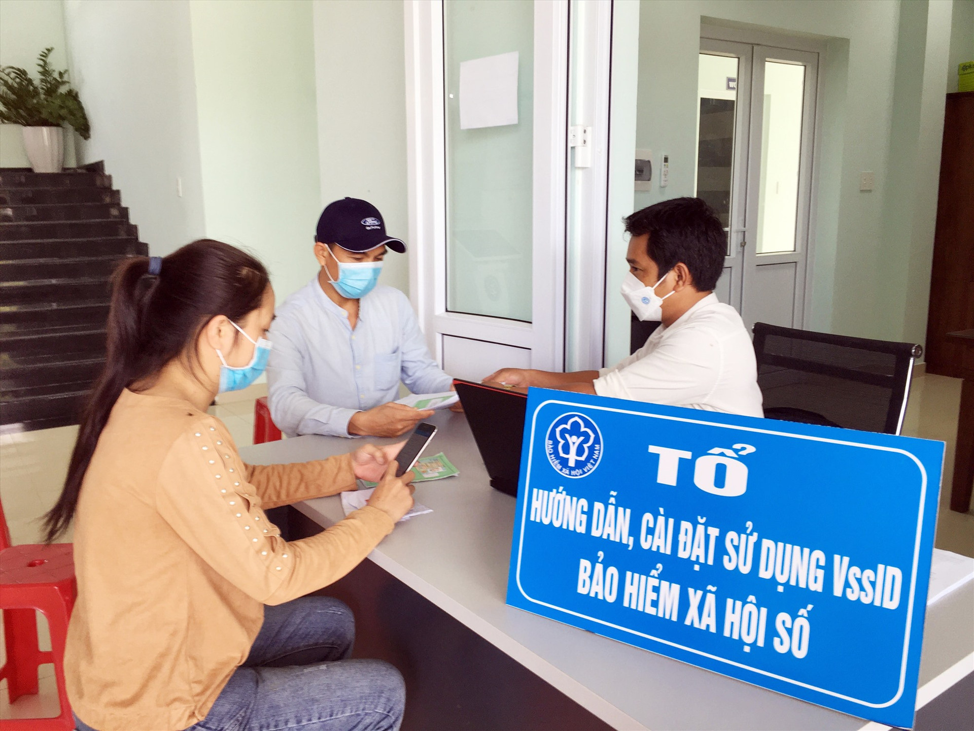BHXH huyện Phú Ninh hướng dẫn người lao động làm thủ tục nhận chế độ theo Nghị quyết 116 của Chính phủ. Ảnh: C.Đ