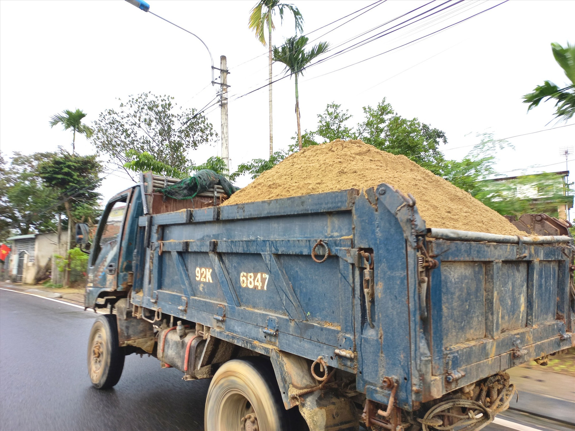 Xe tải chở cát không che đậy lưu thông trên QL40B qua huyện Phú Ninh. Ảnh: K.K