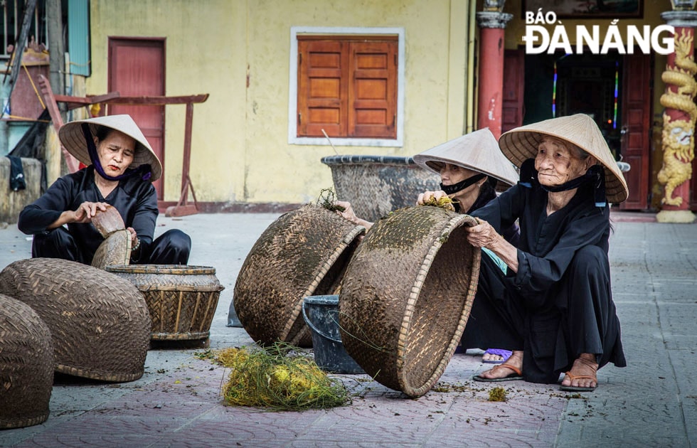 Những phụ nữ lớn tuổi dùng dây tơ hồng chà phân bò vào thúng, theo phương thức truyền thống để khi trét dầu rái vỏ thúng sẽ khít chặt, không rỉ nước.