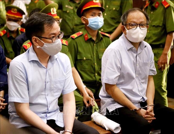 Hai bị cáo của vụ án: Tề Chí Dũng (bên trái) và Tất Thành Cang tại phiên tòa ngày 27/12/2021. Ảnh: Thành Chung/TTXVN