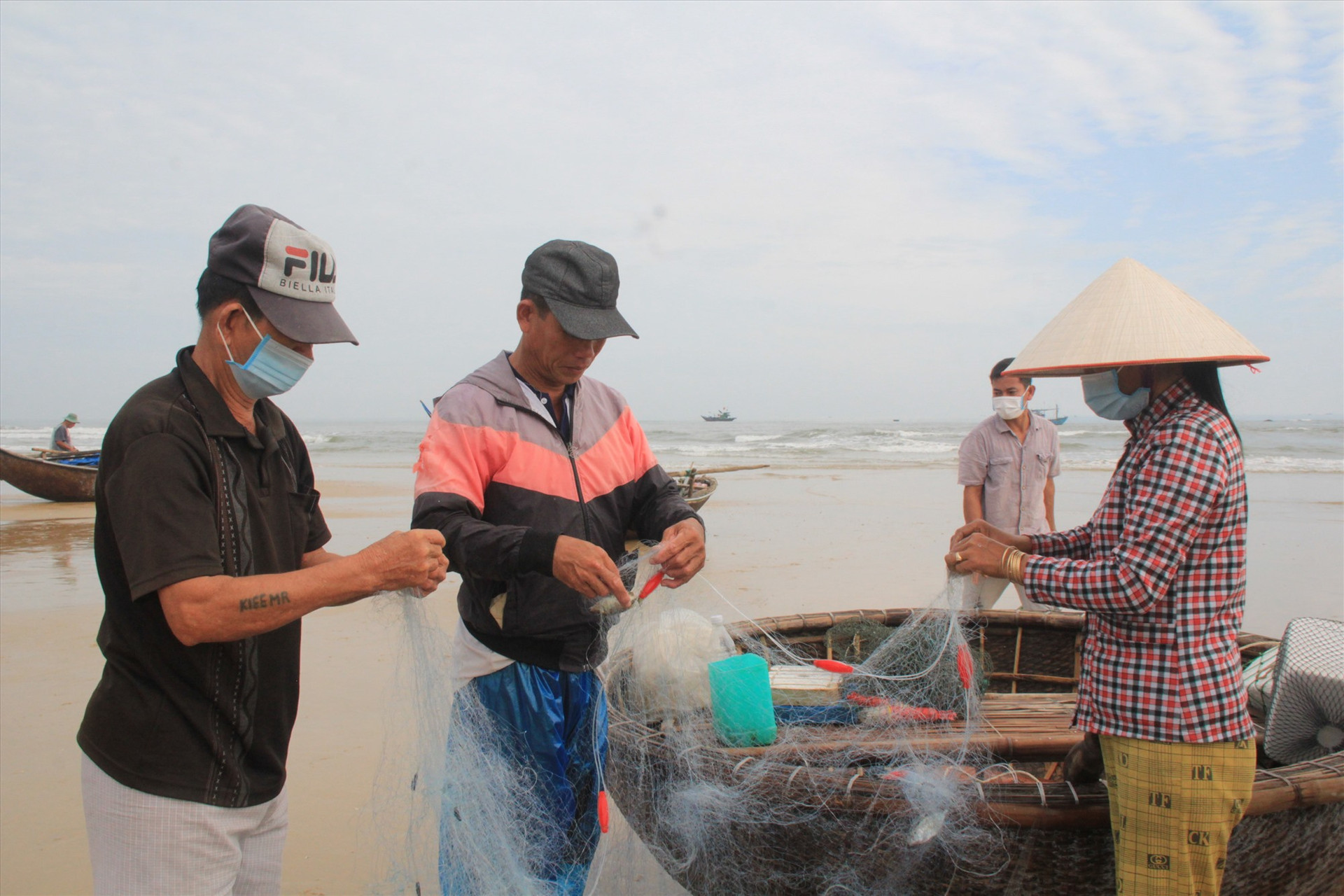 Những người phụ nữ phụ giúp chồng gỡ cá từ lưới ra để bán cho thương lái. Ảnh: LL