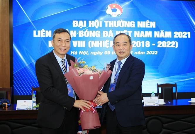 Quyền chủ tịch Liên đoàn Bóng đá Việt Nam Trần Quốc Tuấn nhận hoa chúc mừng từ Nguyên Chủ tịch Liên đoàn Bóng đá Việt Nam khóa VIII Lê Khánh Hải. Ảnh: TTXVN