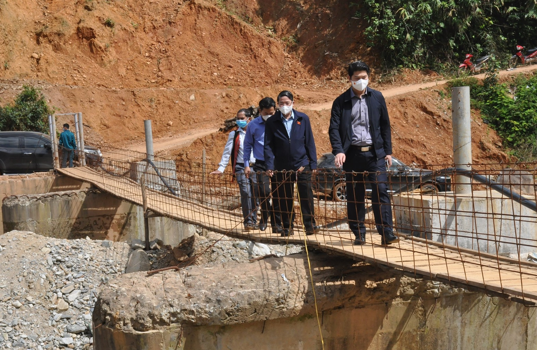 Phó Chủ tịch Quốc hội Nguyễn Đức Hải khảo sát việc xây dựng lại cầu dẫn vào thôn 2, bị trôi do lũ cuối năm 2020. Ảnh: N.Đ