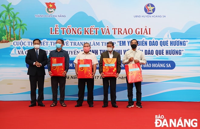 Giám đốc Sở Nội vụ, Chủ tịch UBND huyện Hoàng Sa Võ Ngọc Đồng tặng quà cho các nhân chứng lịch sử về quần đảo Hoàng Sa. Ảnh: XUÂN DŨNG
