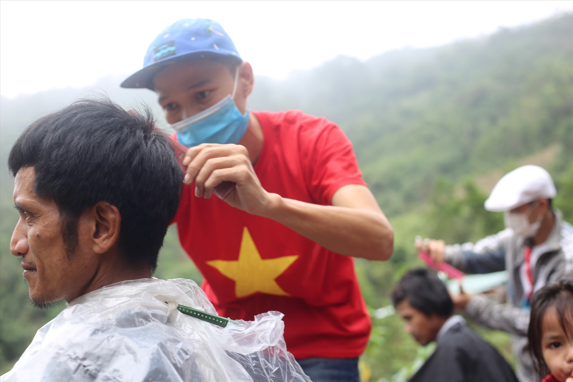 Các tay kéo trẻ đang cắt tóc cho người dân nóc Tắk Nầm.