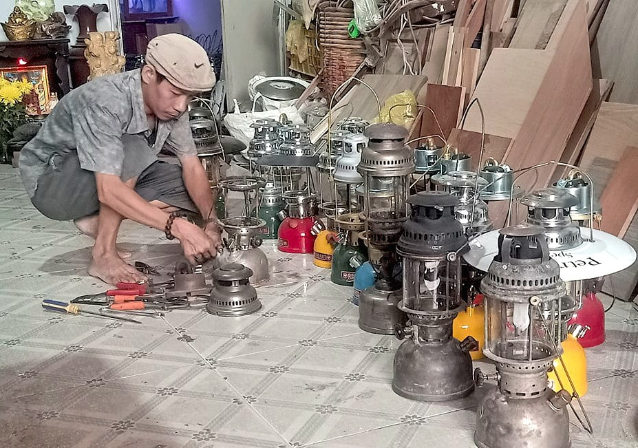 Anh Nguyễn Văn Vương đang sửa chữa đèn măng sông. (Ảnh do nhân vật cung cấp)
