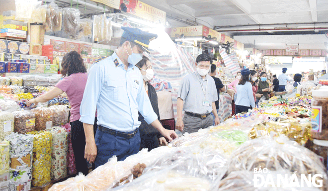 Việc lực lượng chức năng tăng cường kiểm soát thị trường, xử lý nghiêm các vi phạm trong kinh doanh các mặt hàng thiết yếu nhằm bảo đảm quyền lợi người tiêu dùng. Trong ảnh: Cán bộ Đội Quản lý thị trường số 1 (trực thuộc Cục Quản lý thị trường thành phố) kiểm tra hàng hóa Tết tại chợ Hàn.Ảnh: Q.TRANG