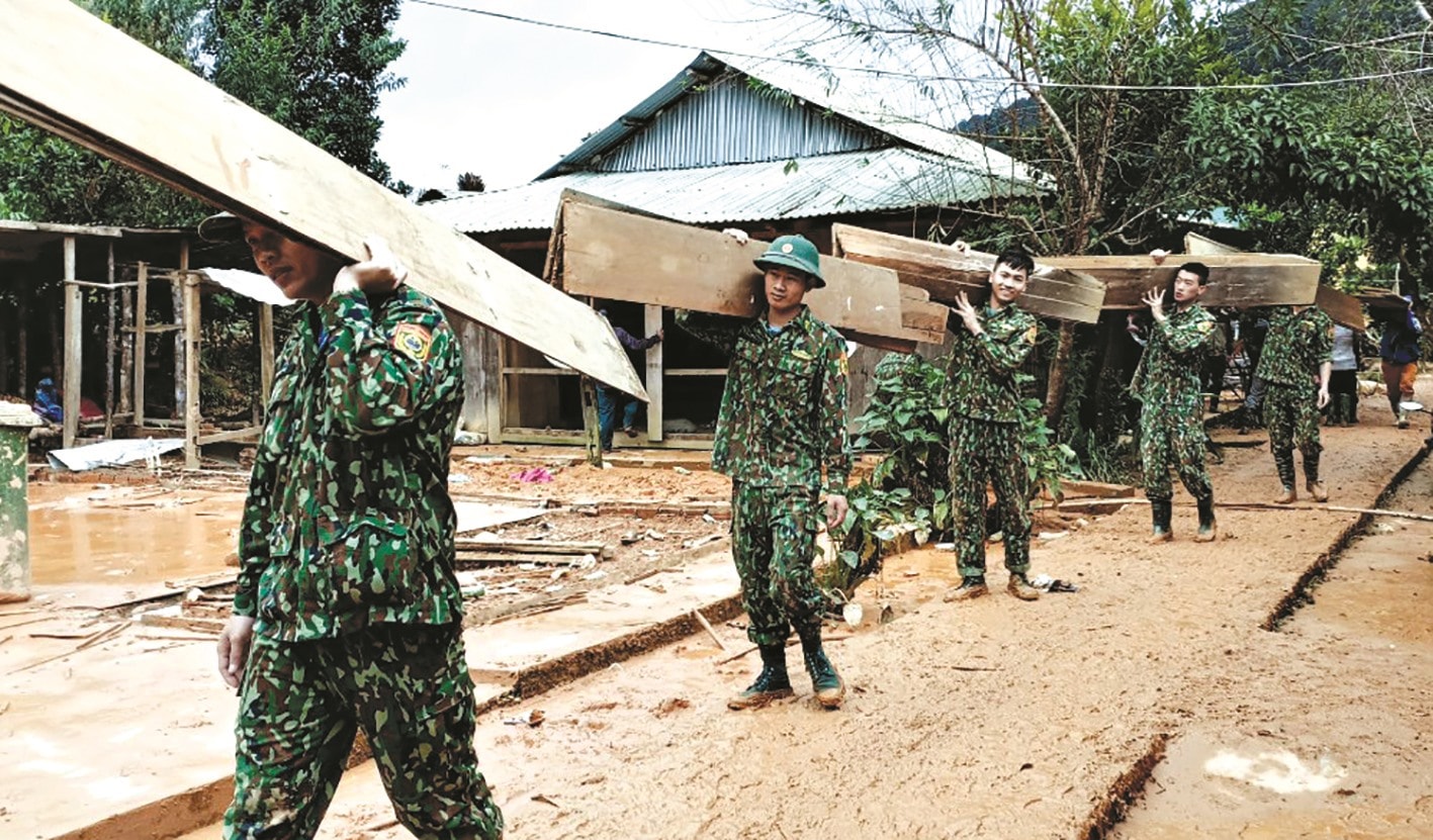 Bộ đội Biên phòng giúp dân dỡ nhà, sơ tán khỏi vùng nguy cơ sạt lở. Ảnh: P.V