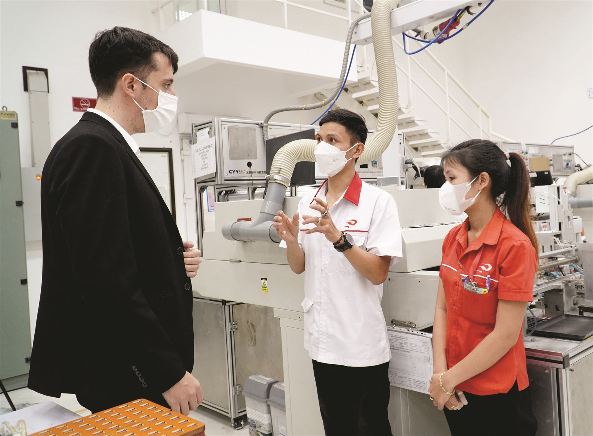 Ông Andrés García Morilla - Giám đốc Công ty TNHH Premo Việt Nam (bên trái) trao đổi cùng người lao động về quy trình sản xuất tại công ty. Ảnh: D.L