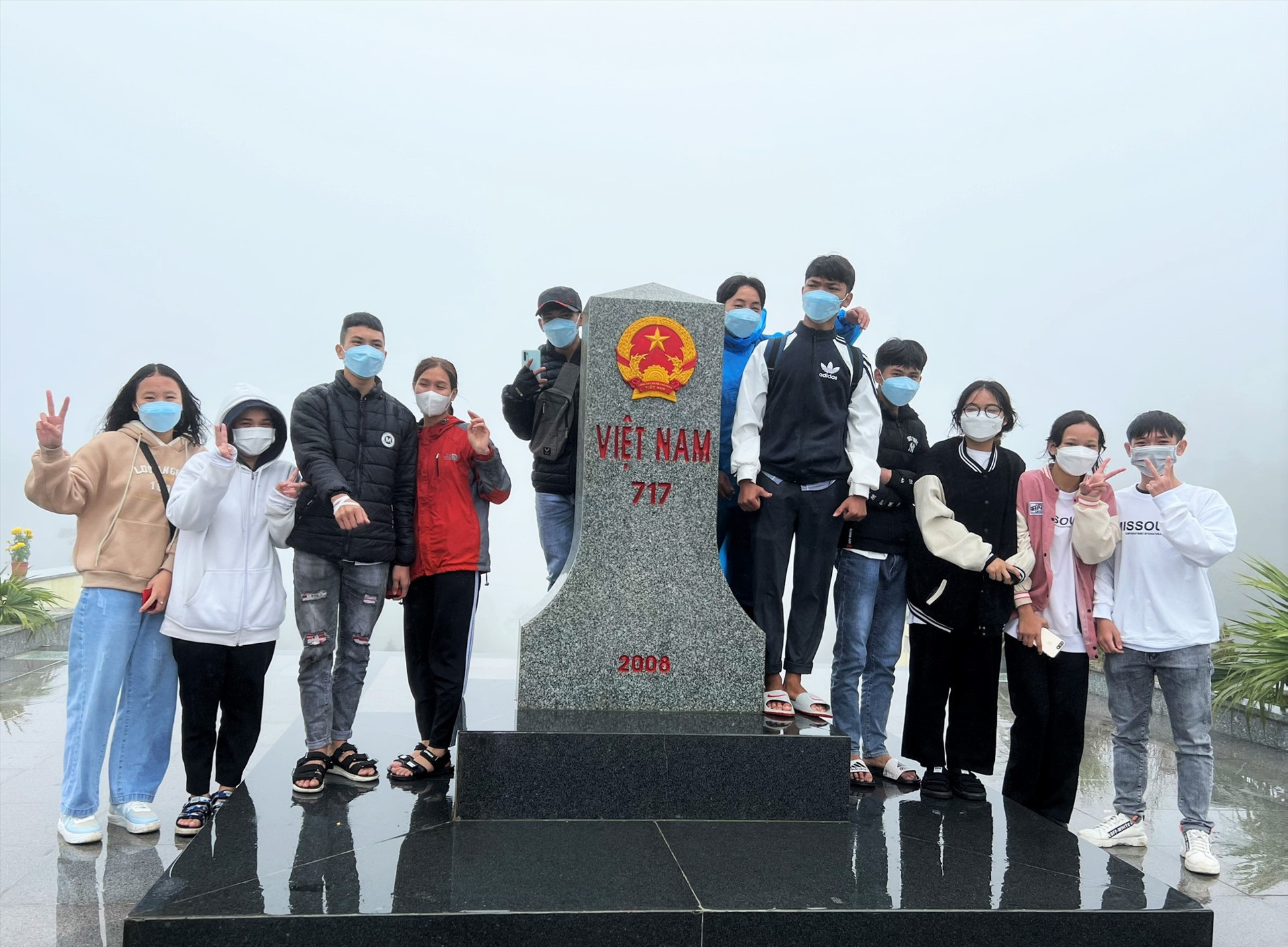 Nhóm bạn trẻ Nam Giang thích thú chụp ảnh lưu niệm tại cột mốc biên giới Việt Nam - Lào trong ngày đầu năm mới. Ảnh: ALĂNG NGƯỚC