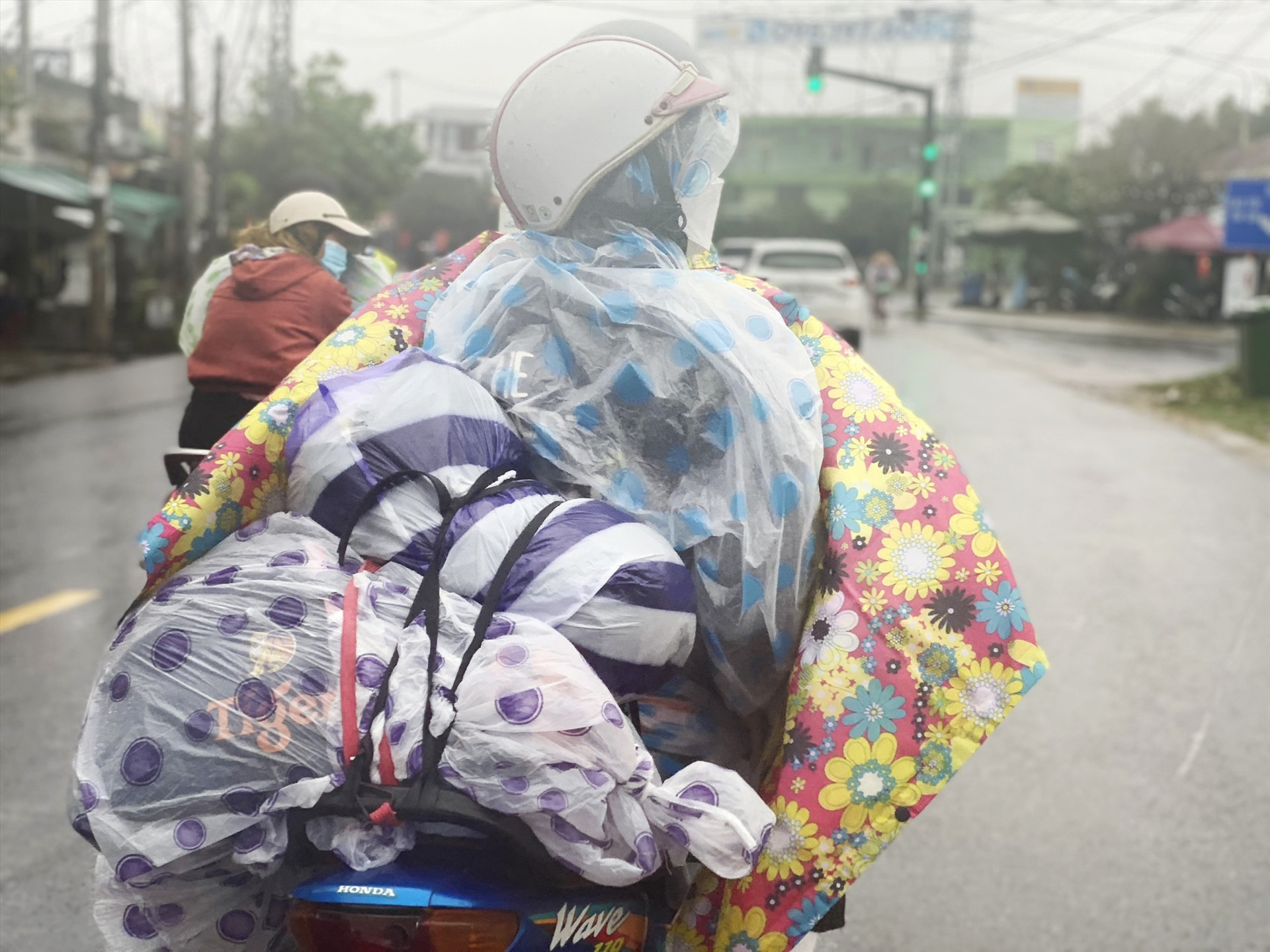Những túi hành lý, hàng hoá được gói lớp ngoài bằng áo mưa tiện lợi để không bị ướt khi trời mưa. Ảnh: H.B