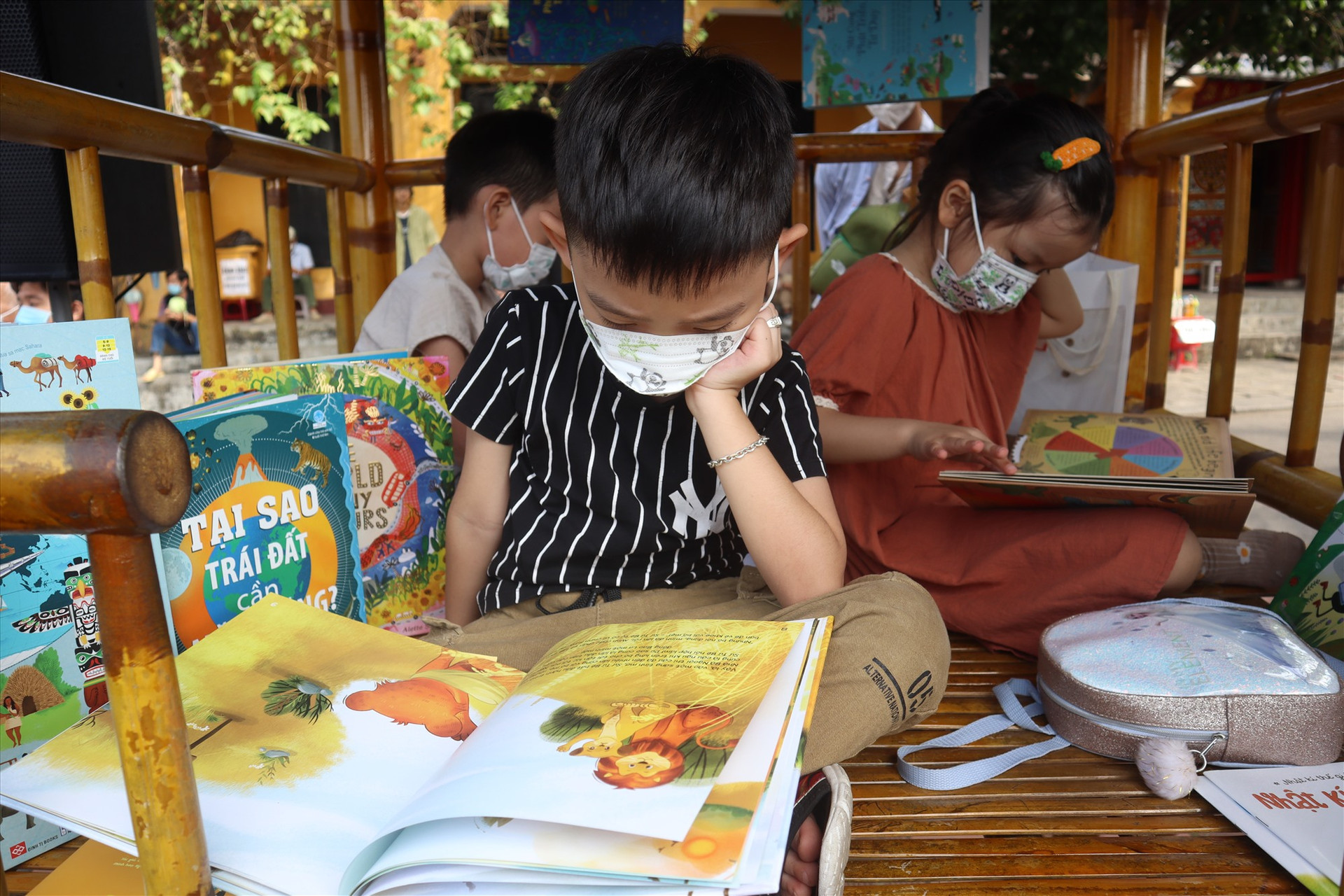 Trẻ em say mê đọc sách bảo vệ môi trường trên chòi. Ảnh: Q.T