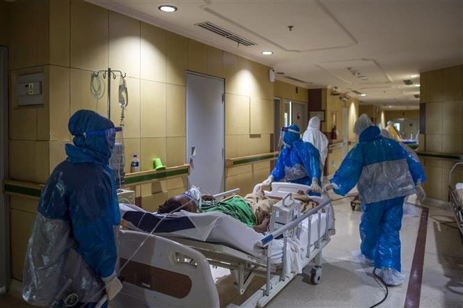 Nhân viên y tế chuyển bệnh nhân Covid-19 tại bệnh viện ở Surabaya, Đông Java, Indonesia. Ảnh: AFP/ TTXVN