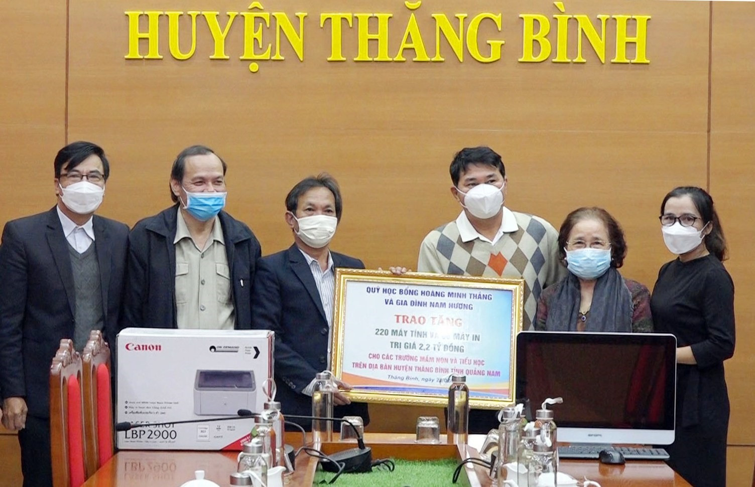 Ông Nguyễn Hoàng Nam (thứ 3 từ phải qua) trao biểu trưng tặng máy tính và máy in cho lãnh đạo huyện Thăng Bình. Ảnh: T.N