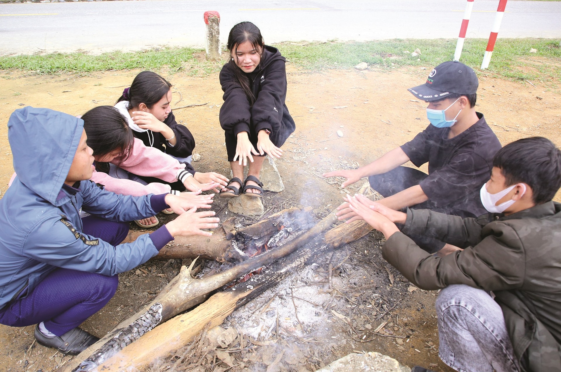 Học sinh Trường THPT Quang Trung (Đông Giang) đốt lửa sưởi ấm bên vệ đường vào buổi trưa sau giờ học.