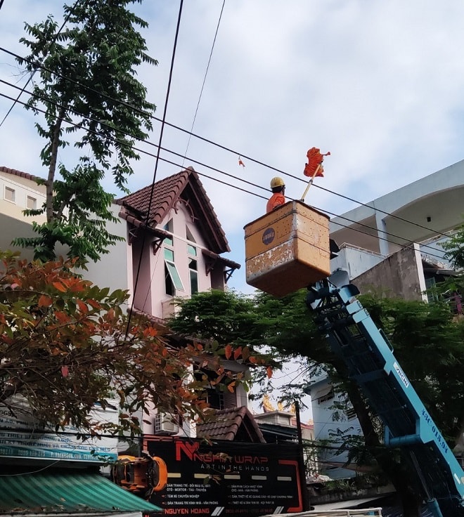 Công nhân Điện lực Hải Châu xử lý bóng bay trước số nhà 215 Nguyễn Hoàng.