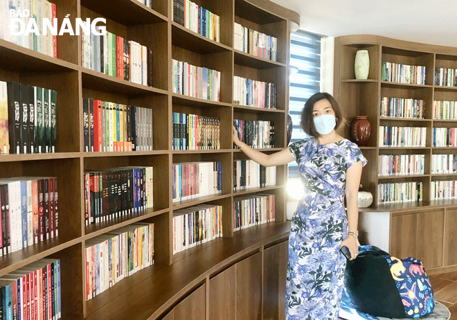 Chị Tống Thu Huyền - Điều hành dự án thư viện triển lãm cộng đồng Olive Gallery Đà Nẵng giới thiệu về không gian thư viện. Ảnh: N.QUANG