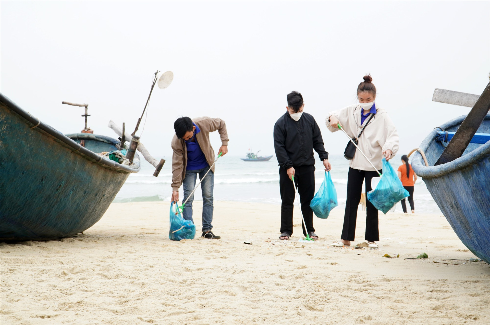 Đoàn viên, thanh niên tham gia dọn vệ sinh bãi biển. Ảnh: H.Q