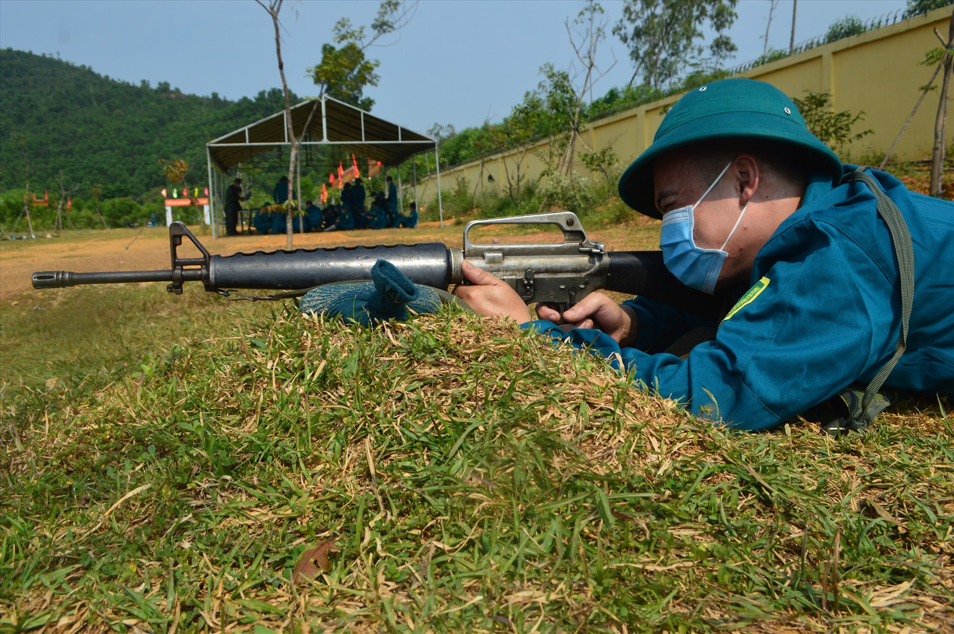 Dân quân Nguyễn Quy đang thực hiện động tác nằm bắn súng AR15.