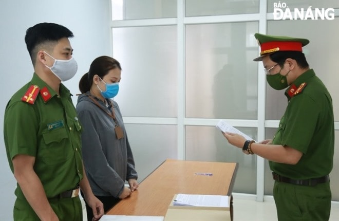 Văn phòng Cơ quan cảnh sát điều tra, Công an thành phố thực hiện quyết định khởi tố bị can đối với Nguyễn Thị Thùy Trang (thứ 2, trái sang). Ảnh: L.H