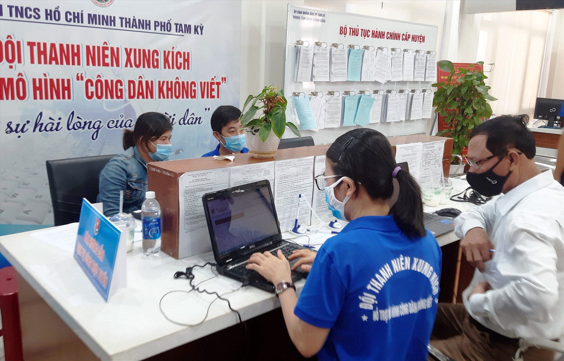 Đoàn viên thanh niên hướng dẫn người dân thực hiện dịch vụ công trực tuyến mức độ 3, 4 tại Trung tâm Hành chính công Tam Kỳ. Ảnh: Q.S