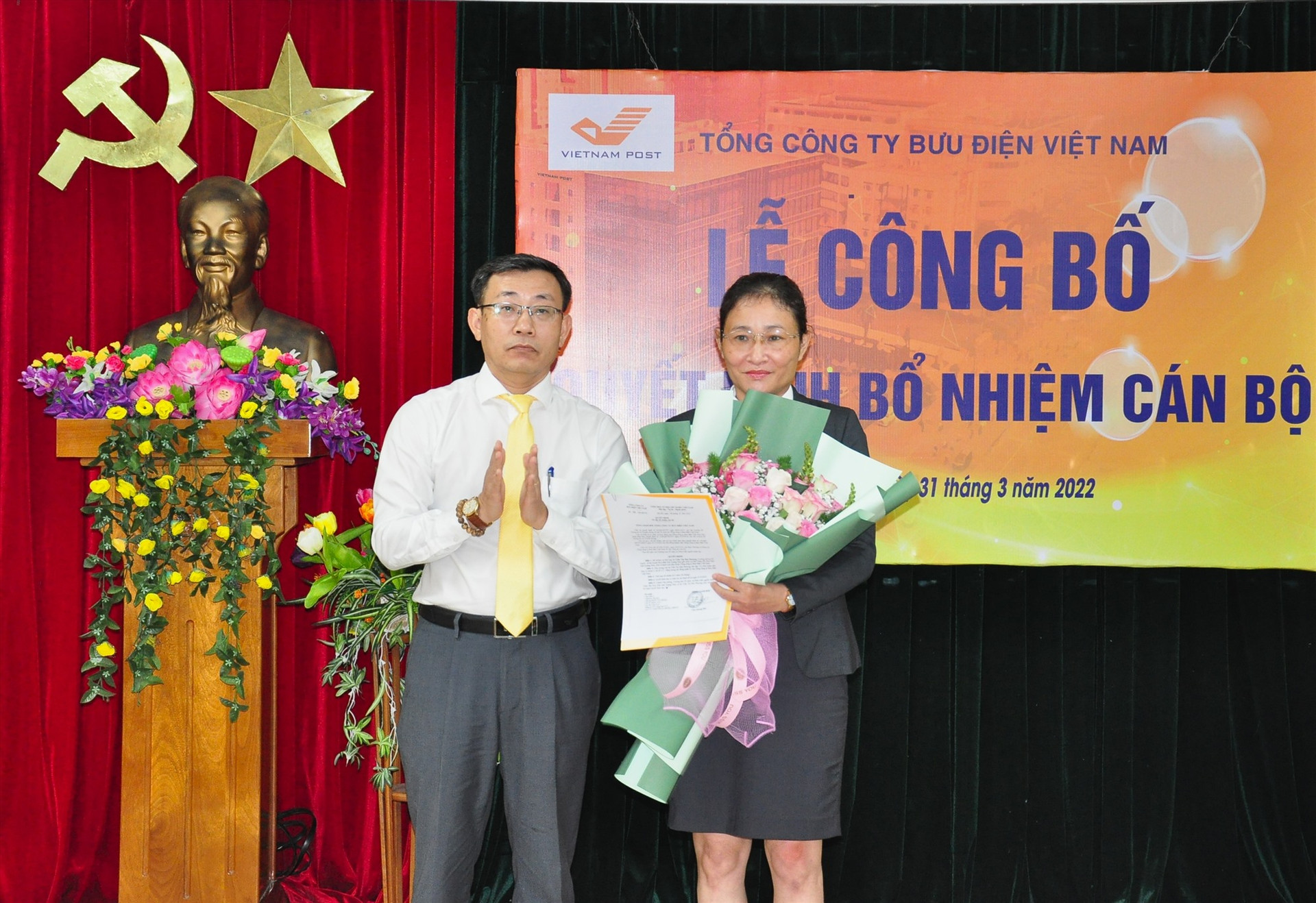 Ông Trần Việt Hùng thay mặt Tổng Công ty Bưu điện Việt Nam trao quyết định bổ nhiệm và tặng hoa chúc mừng bà Trần Thị Mai Phương. Ảnh: V.A
