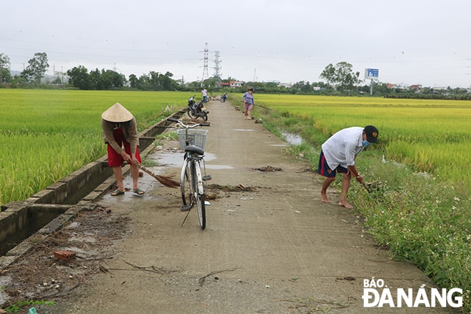 Nông dân thôn Phong Nam, xã Hòa Châu đang dọn dẹp kênh mương trong sáng 2-4. Ảnh: VĂN HOÀNG