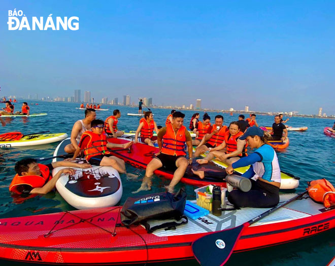 Du khách trải nghiệm dịch vụ chèo sup tại biển Đà Nẵng. Ảnh: T.Y