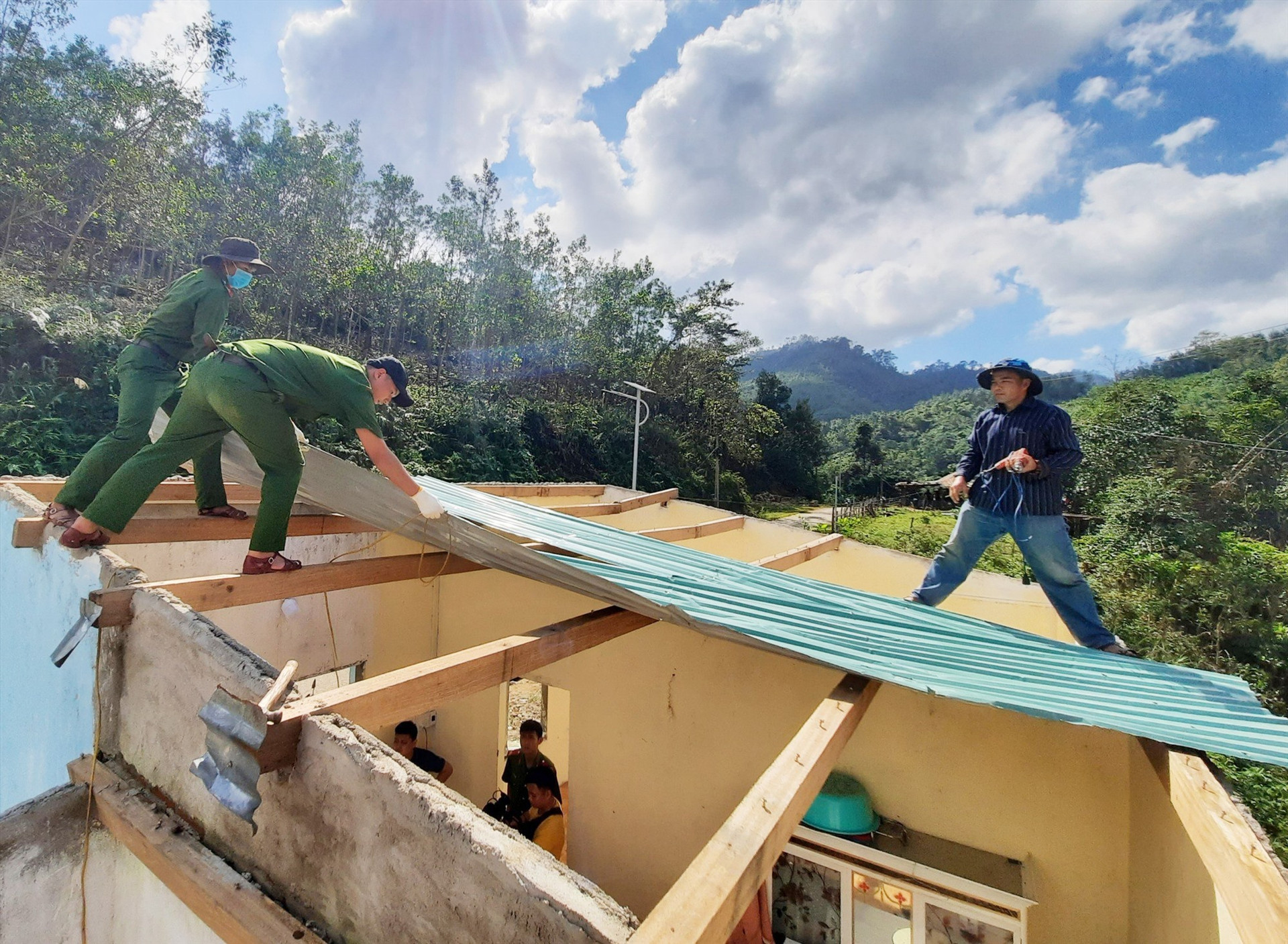Đoàn viên thanh niên Công an tỉnh Quảng Nam tham gia sửa chữa, lợp lại mái tôn giúp người dân bị thiên tai. Ảnh: Đ.Q
