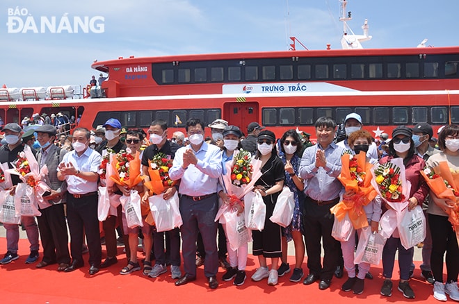 20 du khách đầu tiên được tặng hoa và quà lưu niệm trong chuyến tàu Đà Nẵng - Lý Sơn. Ảnh: THÀNH LÂN - VĂN HOÀNG