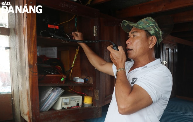Ngư dân quận Sơn Trà vượt khó, vươn khơi bám biển để ổn định sản xuất. Trong ảnh: Anh Nguyễn Văn Bình, ngư dân phường Thọ Quang kiểm tra máy giám sát hành trình để chuẩn bị cho chuyến vươn khơi sắp đến. Ảnh: VĂN HOÀNG