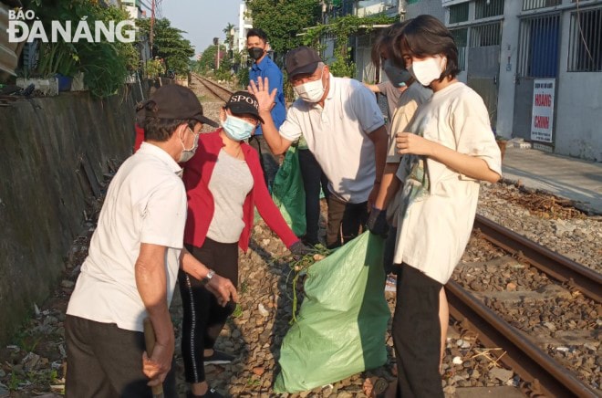 Các cựu chiến binh, đoàn viên thanh niên phường Chính Gián, quận Thanh Khê thu gom rác dọc tuyến đường sắt.