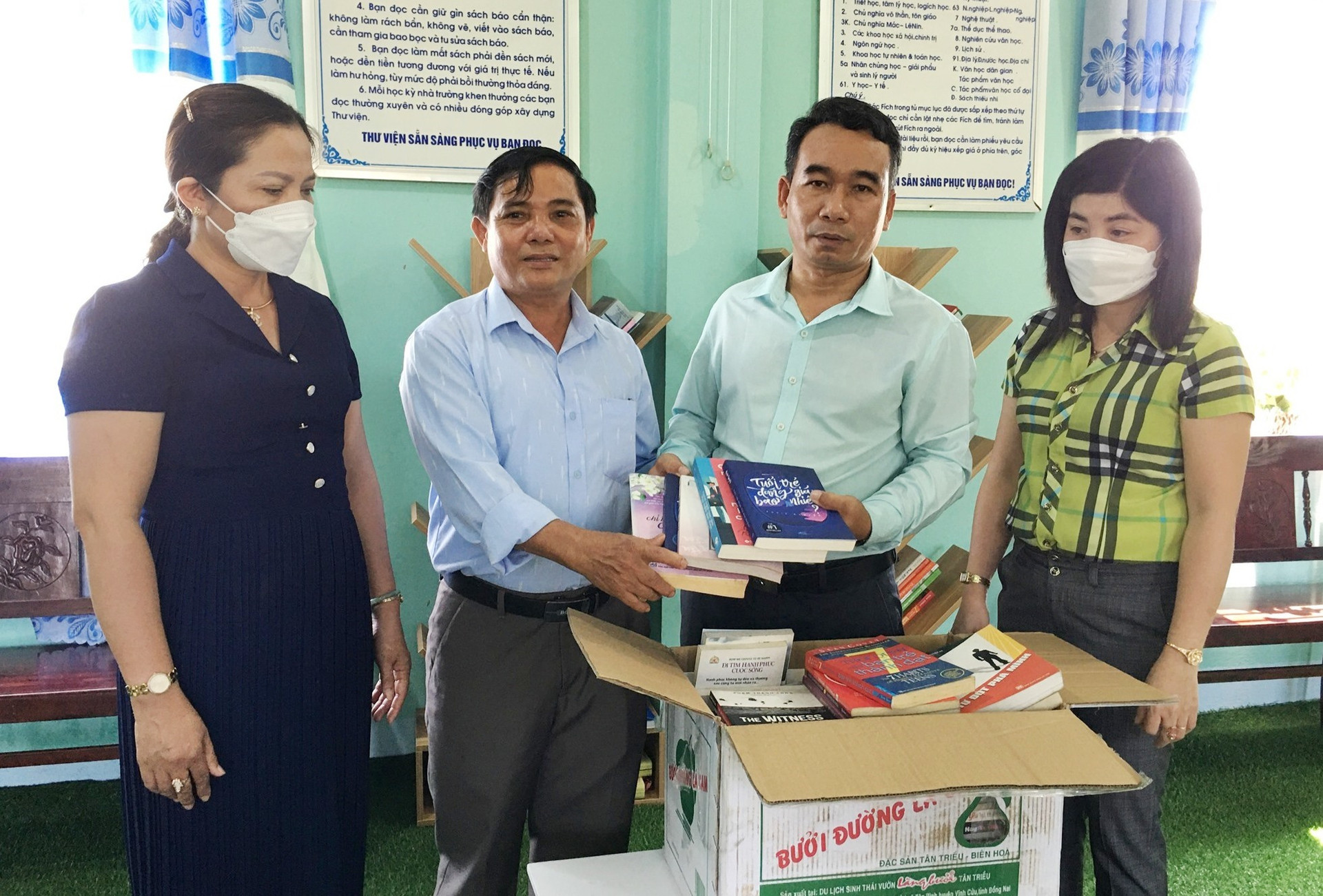 Ông Phan Văn Hiệp (thứ 2 từ trái sang) thường xuyên kêu gọi bạn bè, nhà hảo tâm hỗ trợ kinh phí và đóng góp sách tặng các trường học tại quê nhà. Ảnh: C.Đ