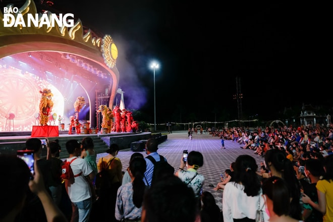 Du khách thưởng thức múa lân tại Công viên Châu Á. Ảnh: THU HÀ.