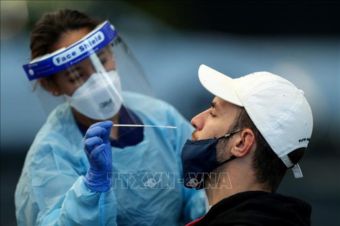 Nhân viên y tế lấy mẫu xét nghiệm COVID-19 cho người dân tại Sydney, Australia ngày 13/7/2021. Ảnh: AFP/TTXVN