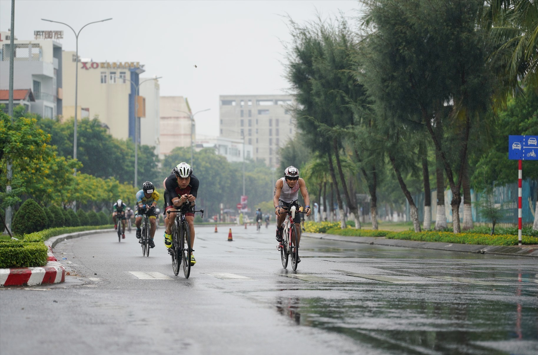 Các vận động viên vượt qua bài thi đạp xe dưới cơn mưa tầm tã. Ảnh: Q.T