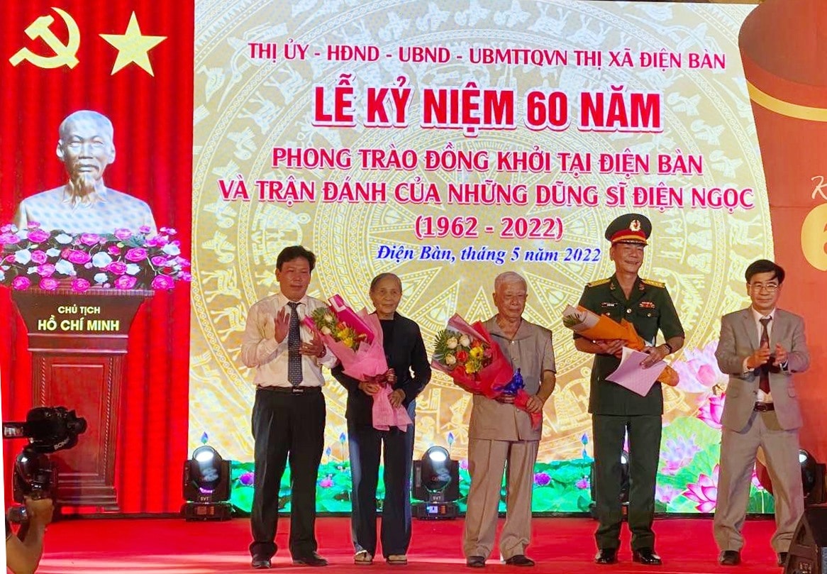 Ông Bùi Hoanh (giữa) và các nhân chứng được lãnh đạo tặng hoa tri ân trong lễ kỷ niệm 60 năm phong trào Đồng khởi ở Điện Bàn. Ảnh: V.LỘC