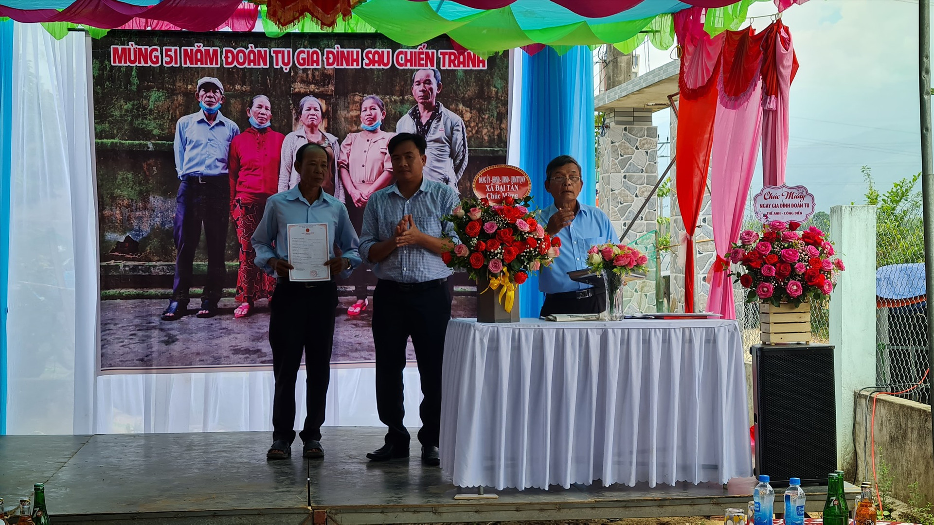 Lãnh đạo địa phương trao giấy khai sinh cho một trong số 5 người con của liệt sĩ Trần Khế và Lê Thị Lục. Ảnh: H.LIÊN
