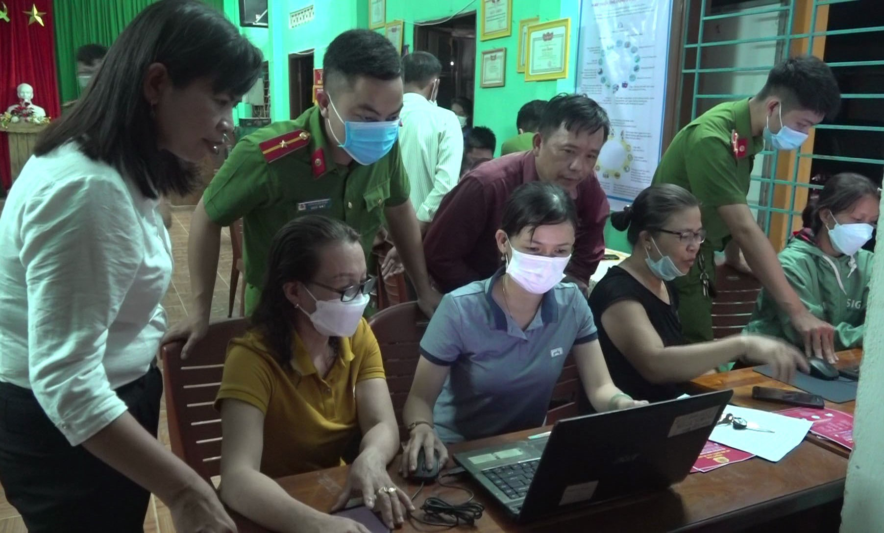 Từ 19 - 20 giờ hằng đêm, cán bộ Công an xã Đại Thạnh hướng dẫn người dân thực hiện các dịch vụ công trực tuyến tại các thôn. Ảnh: X.MAI