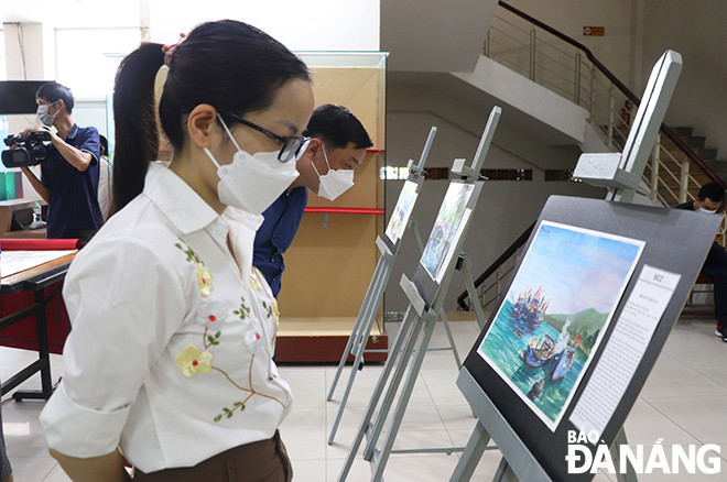Công chúng tham quan, thưỡng lãm các tác phẩm ký họa về làng chài.