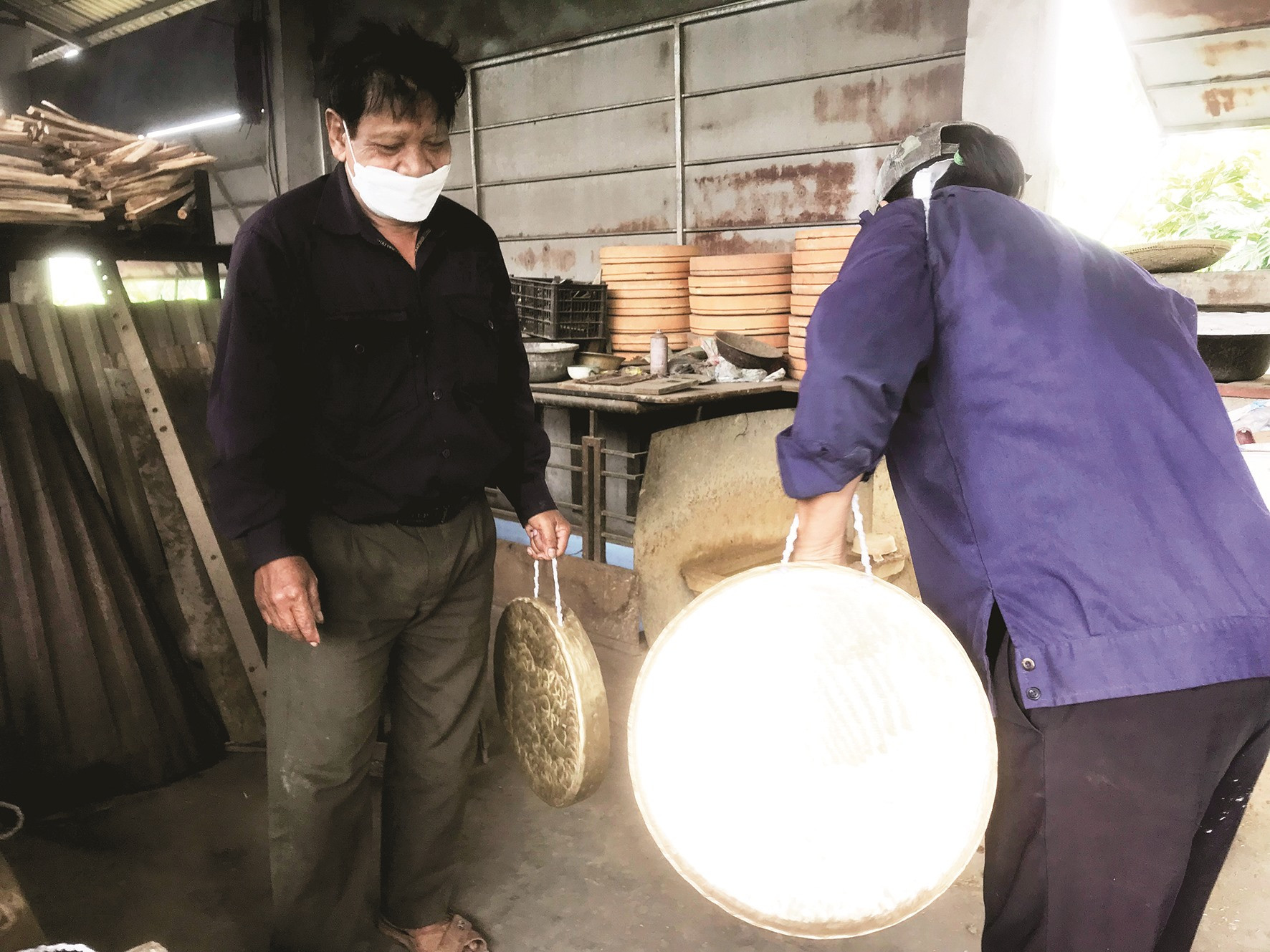 Zơ Râm Đhông kiểm tra bộ chiêng để chuẩn bị giao cho khách Lào.