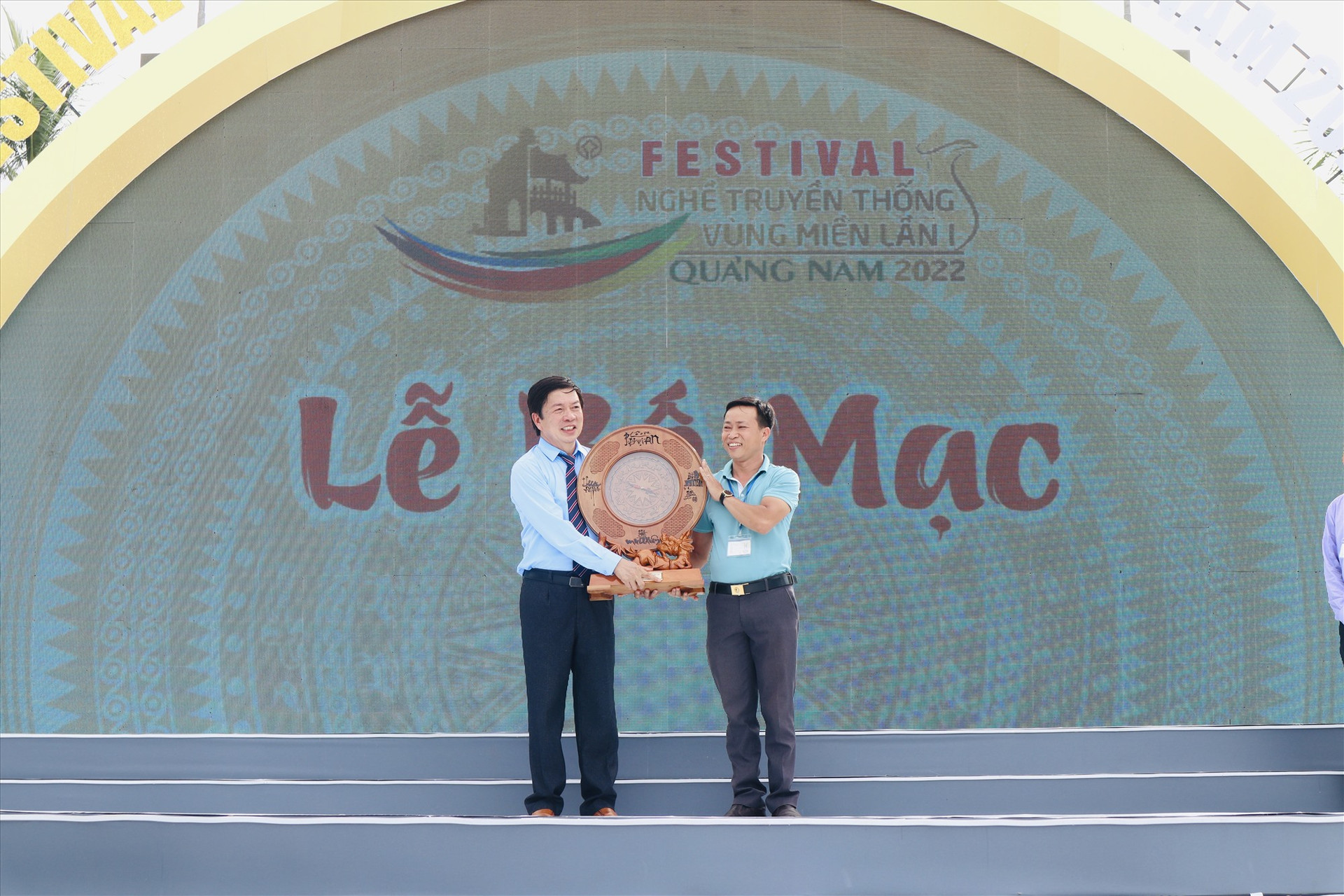 Đại diện ban tổ chức (bên trái) nhận quà lưu niệm từ một đơn vị tham gia Festival. Ảnh: Q.T