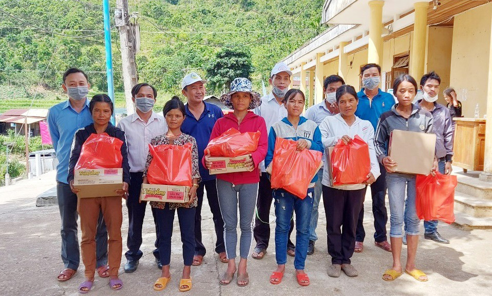Cán bộ Trung tâm VHTT&TTTH huyện Nam Trà My tặng quà và hỗ trợ cây giống các hộ nghèo đăng ký thoát nghèo của xã Trà Vinh. Ảnh: N.Đ