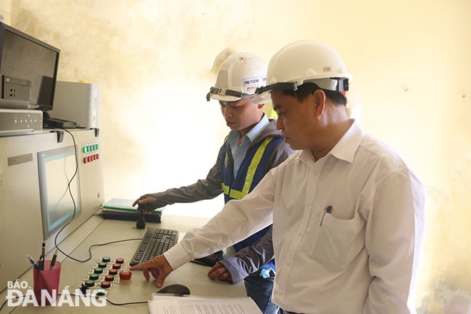 Phó Giám đốc Sở Giao thông vận tải Nguyễn Trung Nghĩa (áo trắng, ngoài cùng), bấm nút nâng cầu trong chiều 4-6. Ảnh: THÀNH LÂN
